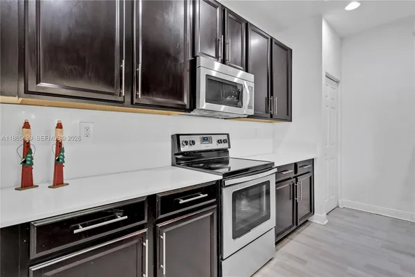 a kitchen with stainless steel appliances a stove microwave and sink