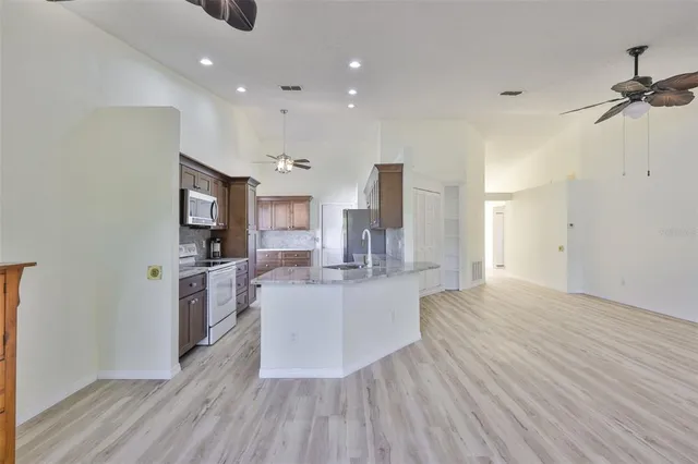 a large white kitchen with wooden floor