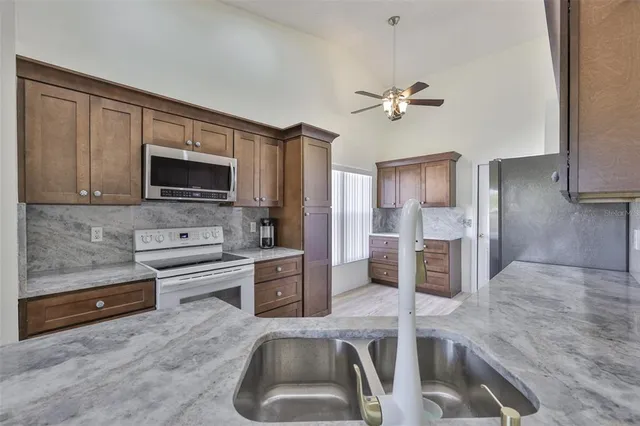 a kitchen with granite countertop a sink and stainless steel appliances