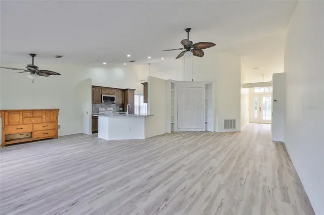 a view of a kitchen with wooden floor and a ceiling fan