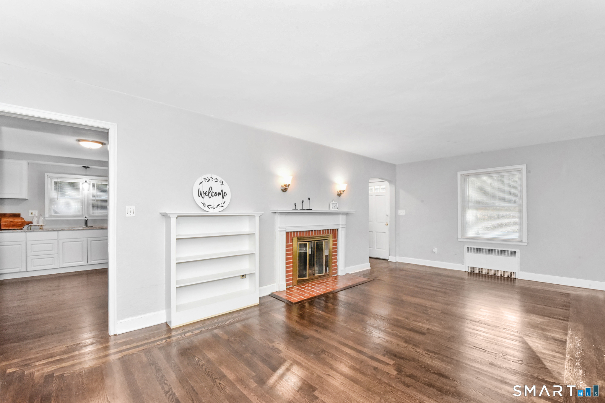 63 Park Road Hamden, CT 06517 - Photo 7 of 39 an empty room with wooden floor fireplace and windows