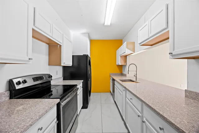 a kitchen with stainless steel appliances granite countertop a sink a stove and a refrigerator