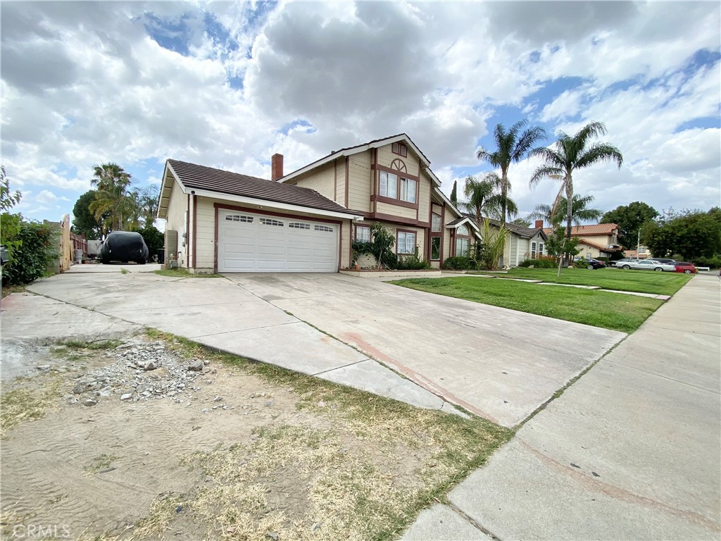 1444 North Sage Avenue Rialto, CA 92376 - Photo 3 of 22 a front view of a house with a yard and garage