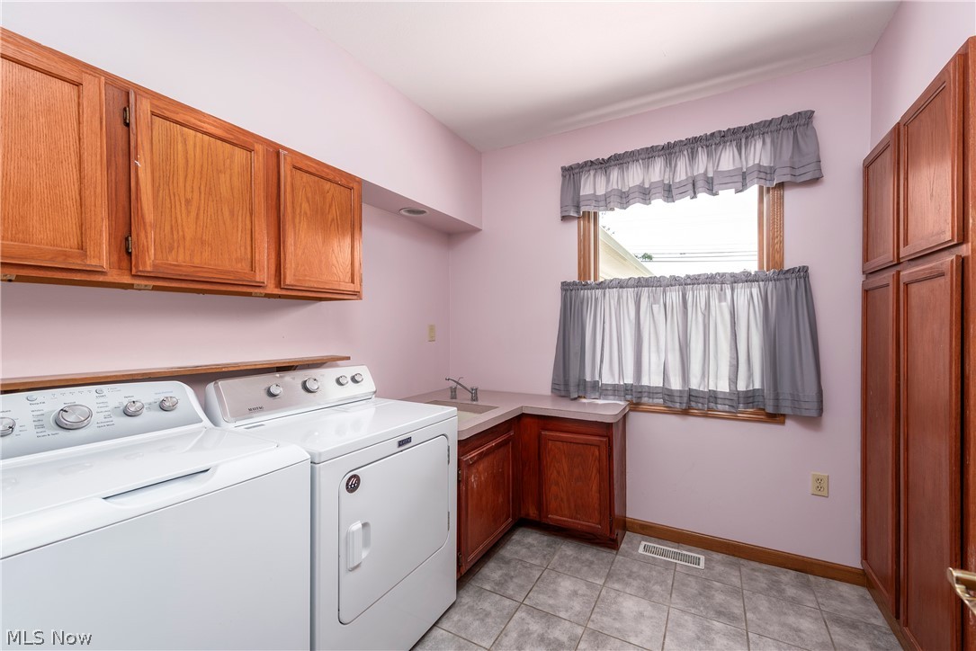 9990 Broadview Road Broadview Heights, OH 44147 - Photo 29 of 47 Laundry room featuring washing machine and clothes dryer, cabinet space, and light tile patterned flooring