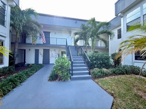 a front view of a house with a yard and potted plants