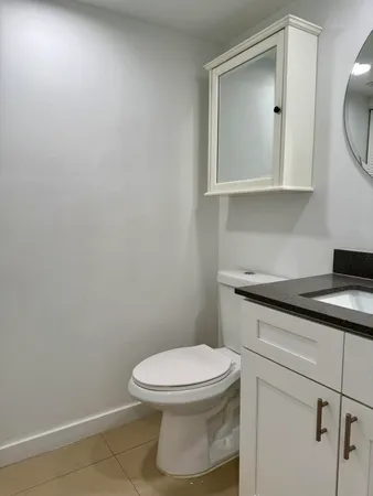 a bathroom with a toilet a sink and mirror