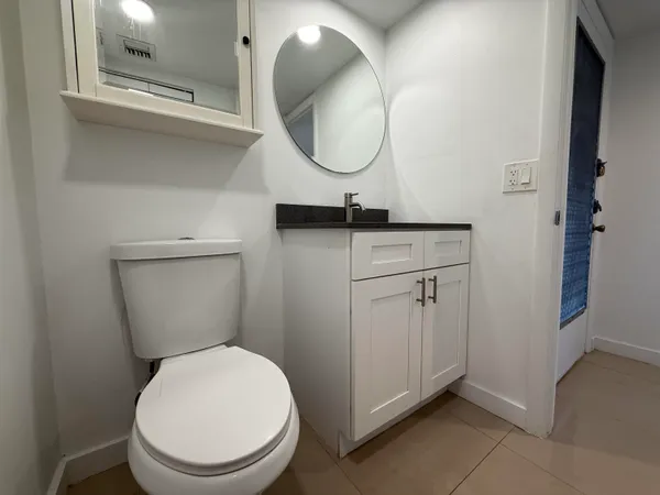 a bathroom with a toilet a sink and mirror