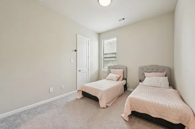 a spacious bedroom with two beds and a window