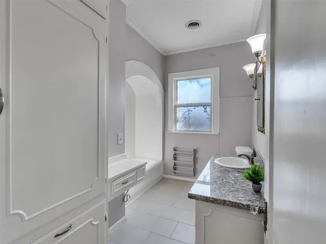 a bathroom with a granite countertop sink a mirror and a bathtub