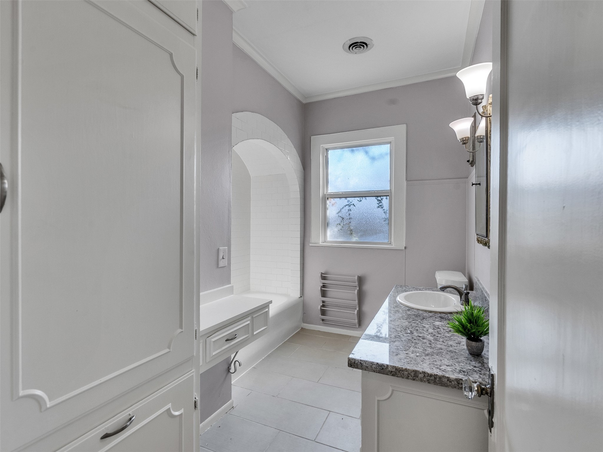 4625 Bell Street Houston, TX 77023 - Photo 13 of 33 a bathroom with a granite countertop sink a mirror and a bathtub