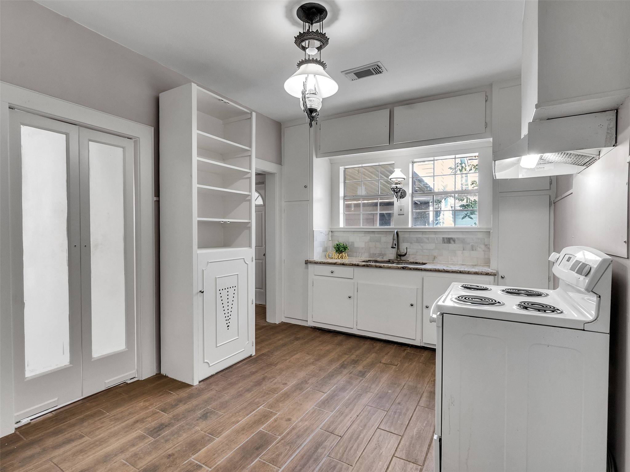 4625 Bell Street Houston, TX 77023 - Photo 27 of 33 a kitchen that has a lot of cabinets and wooden floor