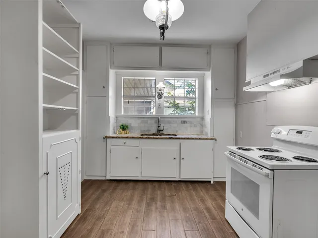 a kitchen that has a stove a table and chairs in it