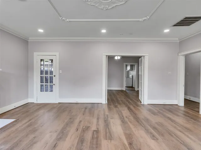 a view of a big room with wooden floor and windows