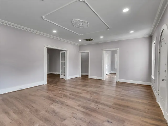 a view of an empty room with wooden floor