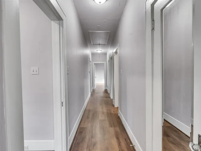 a view of a hallway with wooden floor