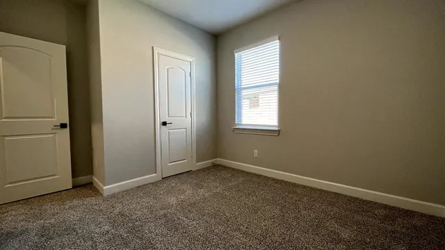 an empty room with windows and closet