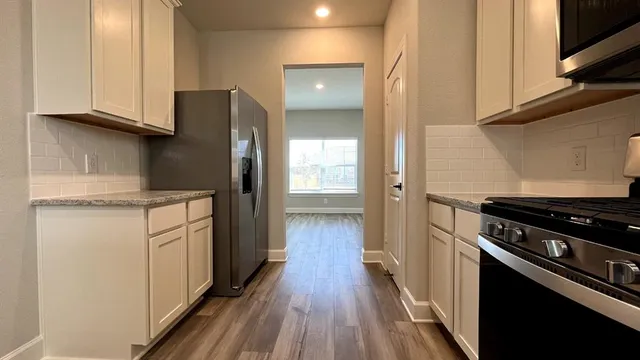 a kitchen with stainless steel appliances granite countertop a stove a sink and a microwave