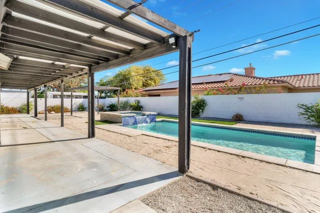 a patio with table and chairs and potted plants