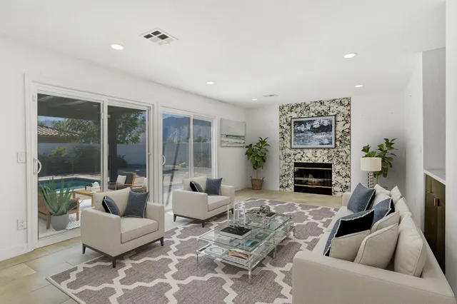 a large white kitchen with stainless steel appliances granite countertop a stove a sink a refrigerator and cabinets