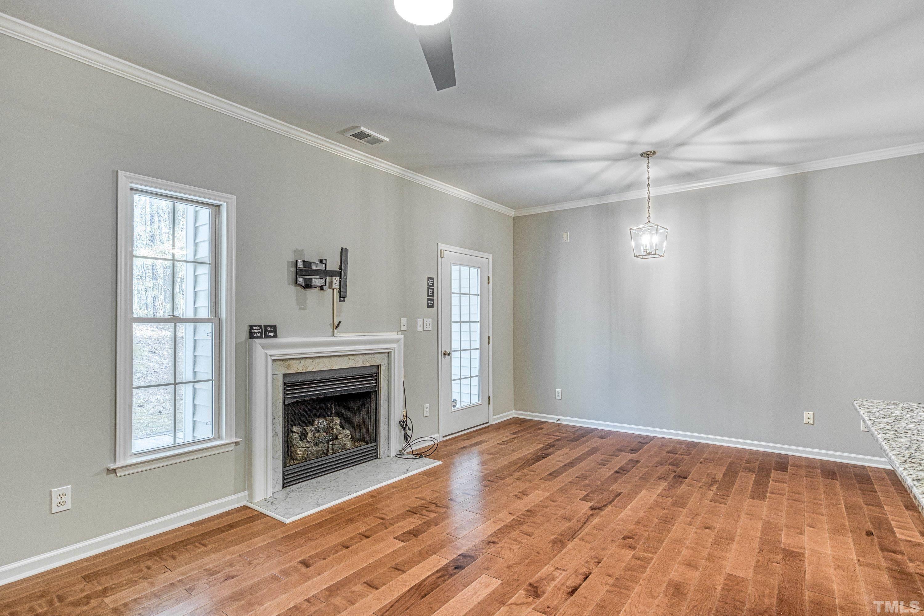 3045 Coxindale Drive Raleigh, NC 27615 - Photo 15 of 42 a view of empty room with wooden floor and fireplace
