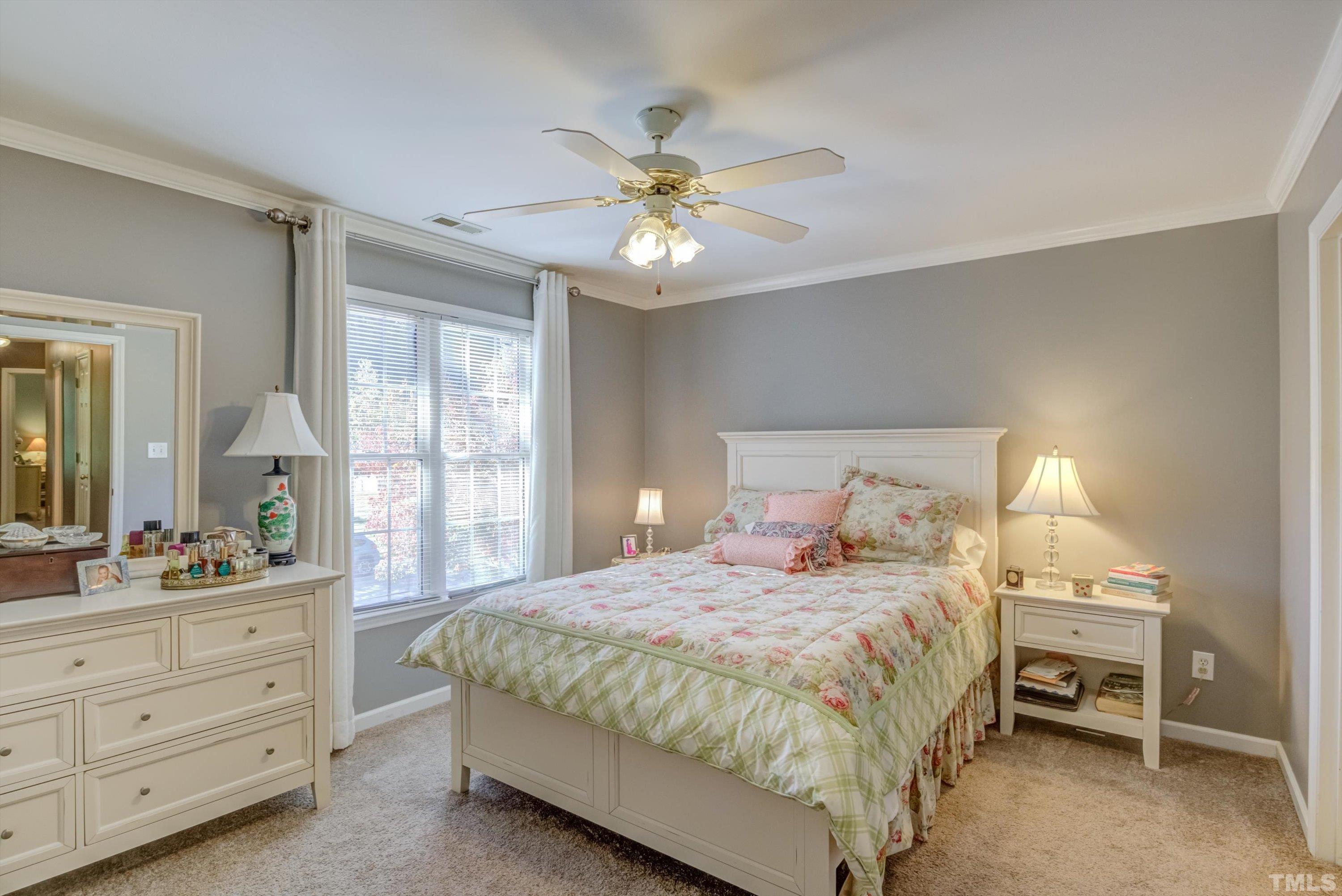 3045 Coxindale Drive Raleigh, NC 27615 - Photo 25 of 42 a bedroom with a bed and a chandelier