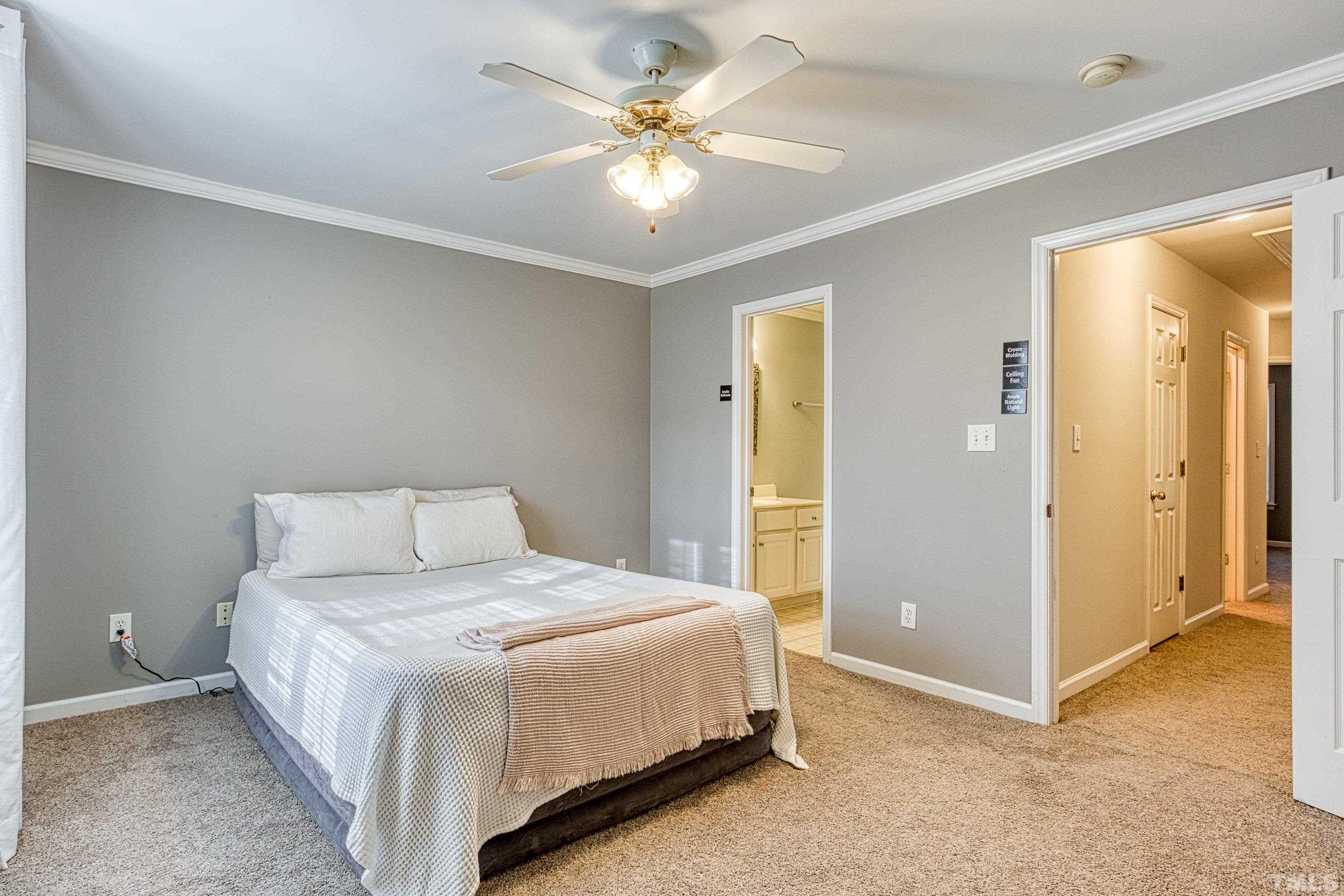 3045 Coxindale Drive Raleigh, NC 27615 - Photo 28 of 42 a bedroom with a bed and a chandelier
