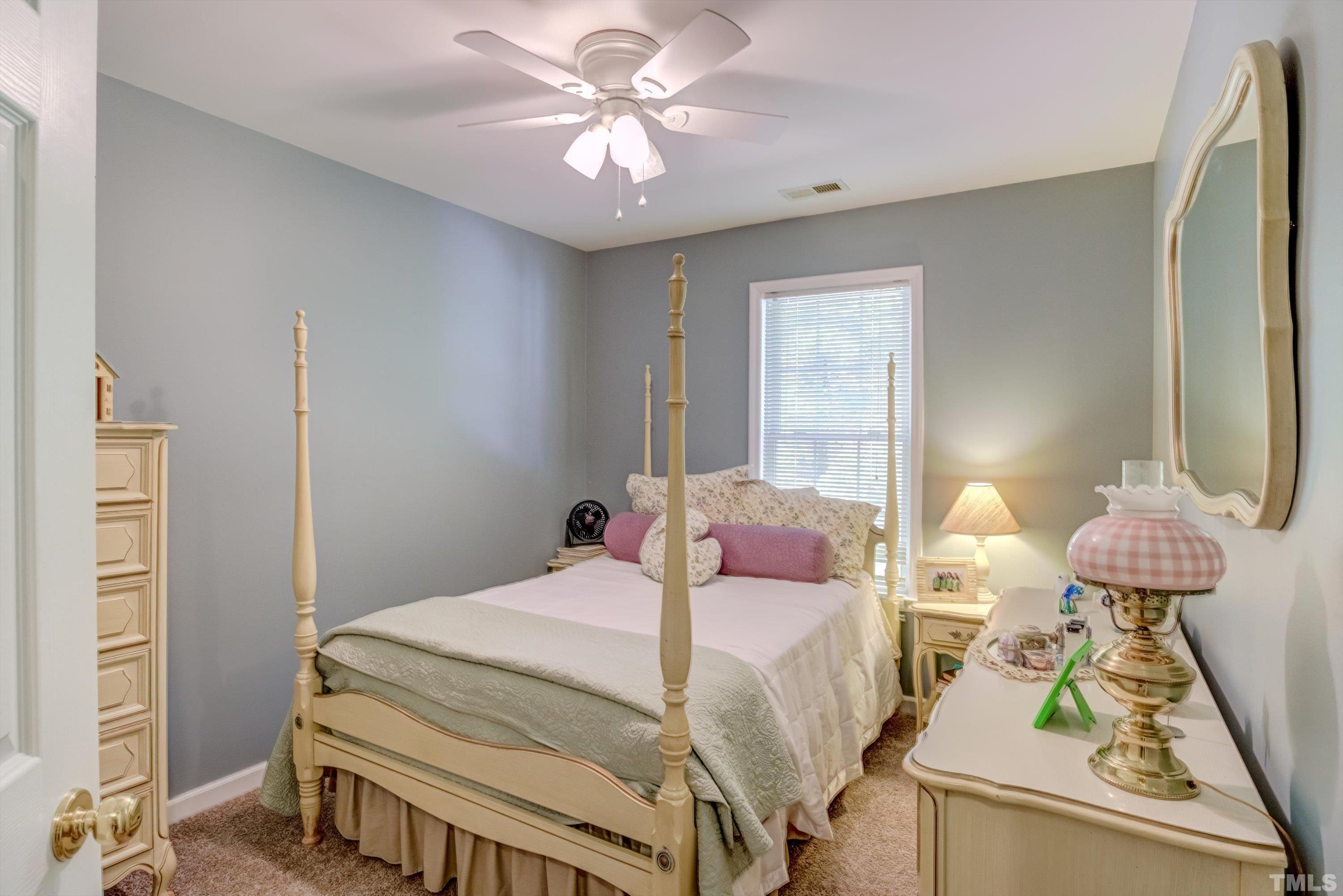 3045 Coxindale Drive Raleigh, NC 27615 - Photo 31 of 42 a bedroom with a bed and a chandelier