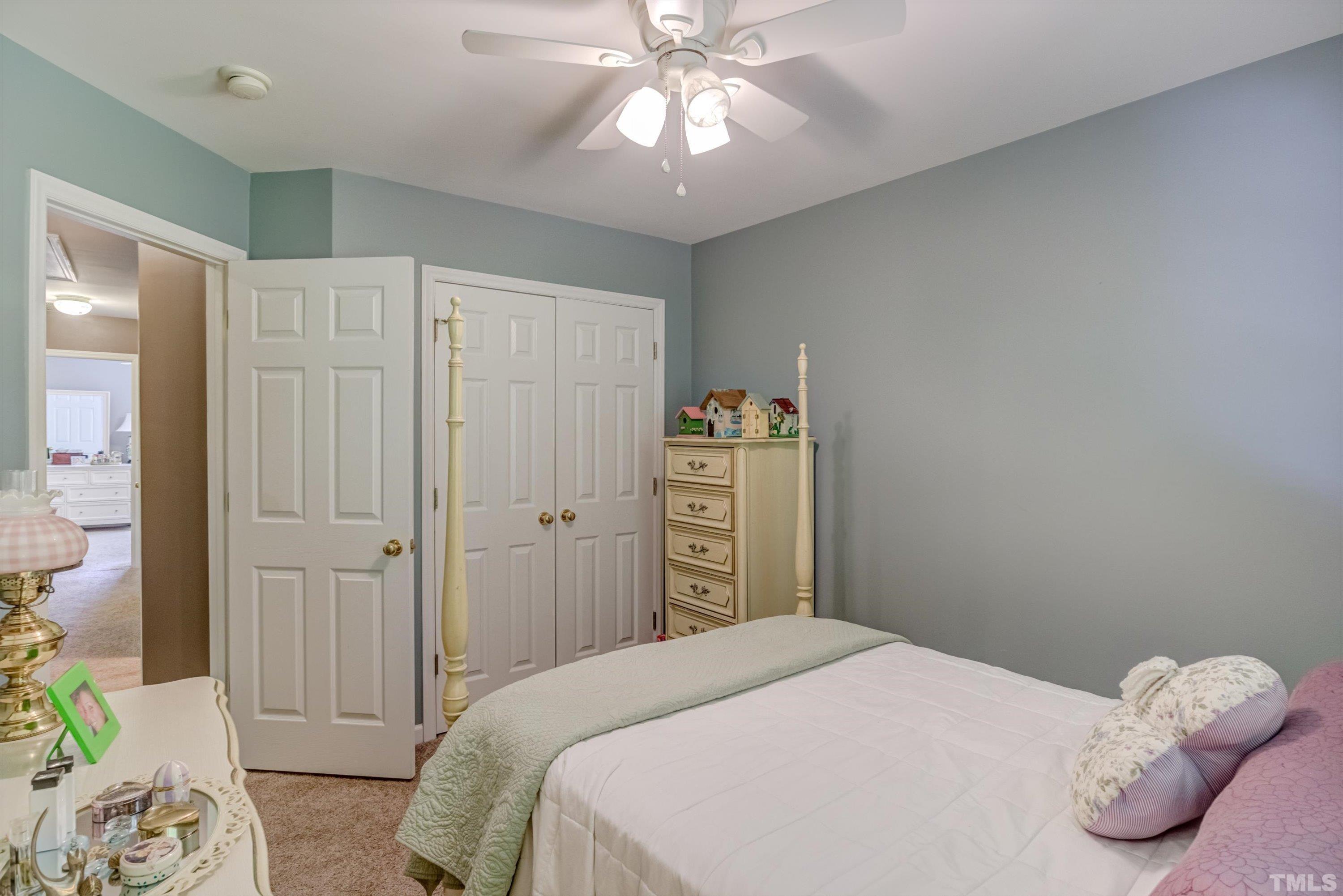 3045 Coxindale Drive Raleigh, NC 27615 - Photo 32 of 42 a bedroom with a bed and a chandelier