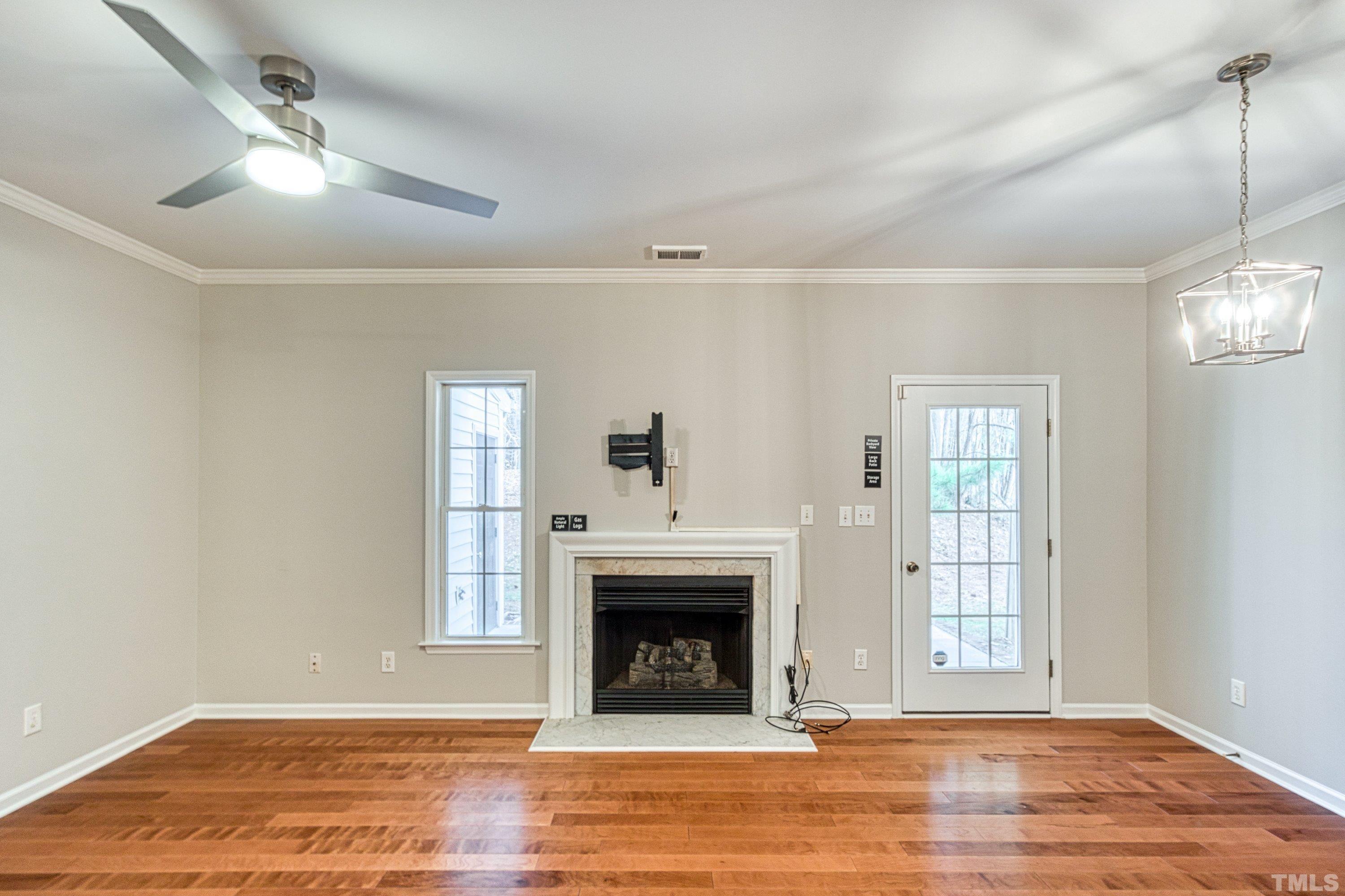 3045 Coxindale Drive Raleigh, NC 27615 - Photo 8 of 42 a view of a livingroom with a fireplace wooden floor and windows