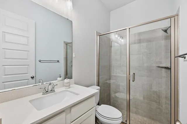 a bathroom with a sink toilet a mirror and shower