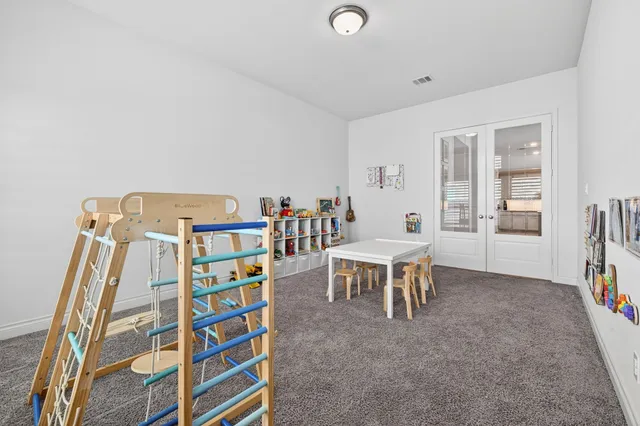 a living room with a baby crib furniture and a book shelf