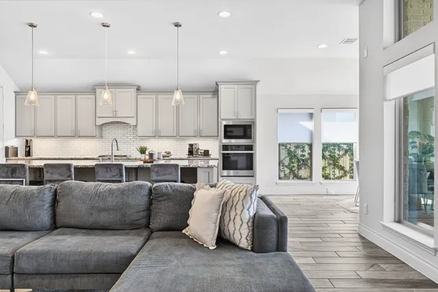a living room kitchen with furniture and a large window