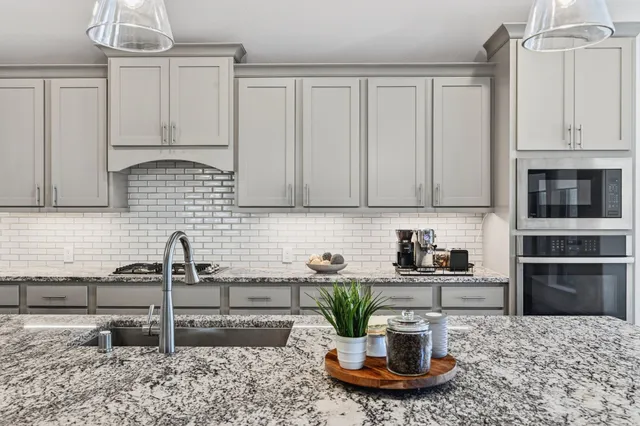 a kitchen with stainless steel appliances granite countertop a sink a stove and a microwave