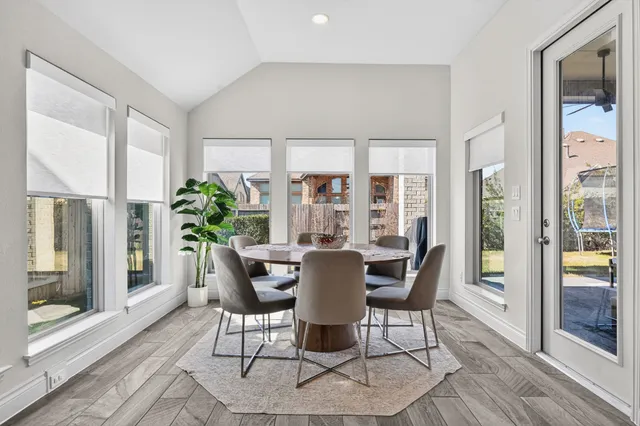 a dining room with furniture window and wooden floor