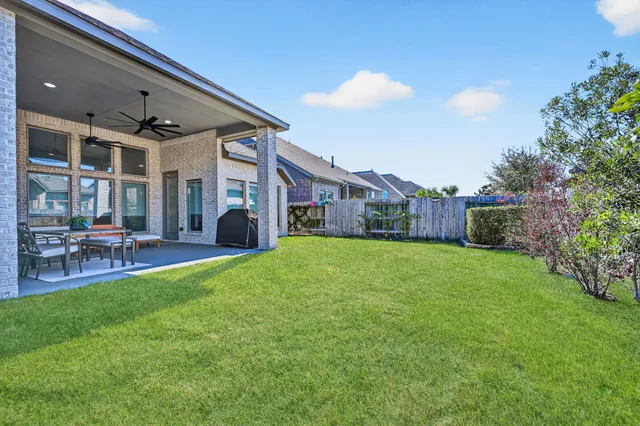 a view of a house with backyard and sitting area