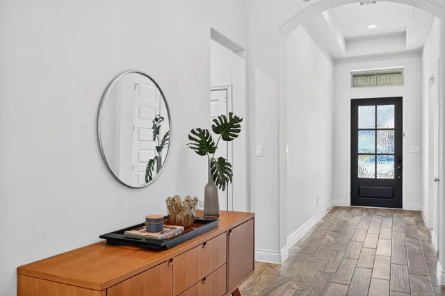 a room with wooden floor and a potted plant