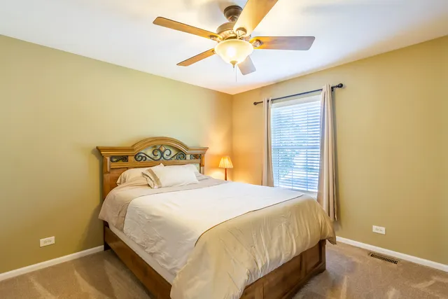 a bedroom with a bed and a ceiling fan