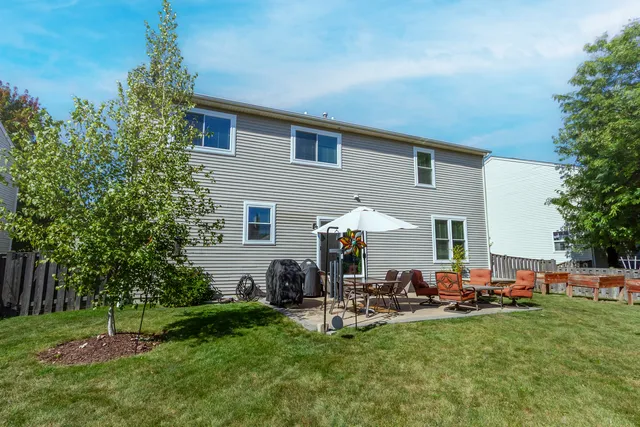 a view of a backyard with table and chairs potted plants and a palm tree