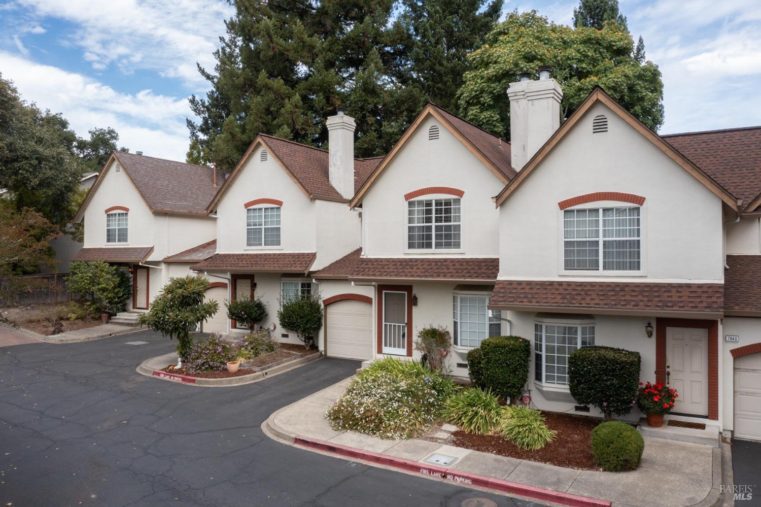a front view of a house with yard and parking