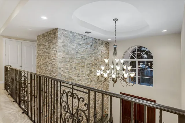 a spacious bedroom with a bed a chandelier and large window