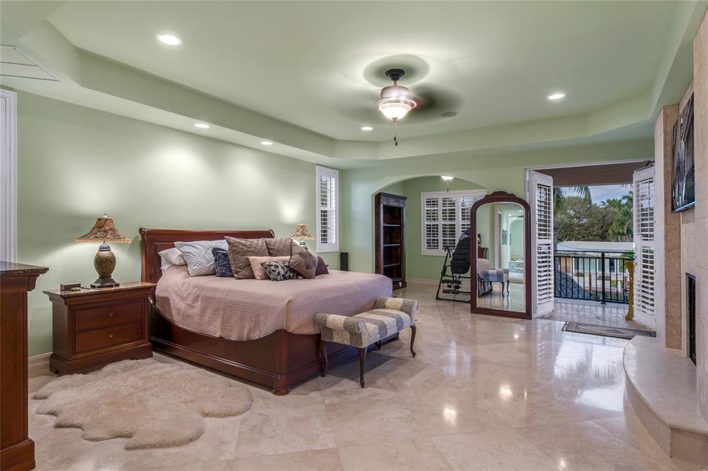 3489 Northeast 30th Avenue Lighthouse Point, FL 33064 - Photo 25 of 42 a spacious bedroom with a bed a chandelier and large window