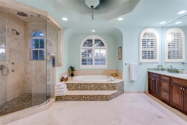 a spacious bathroom with a tub sink and mirror