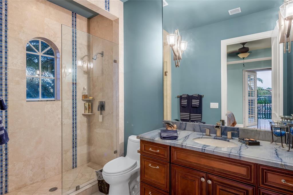 3489 Northeast 30th Avenue Lighthouse Point, FL 33064 - Photo 30 of 42 a bathroom with a granite countertop sink toilet and shower