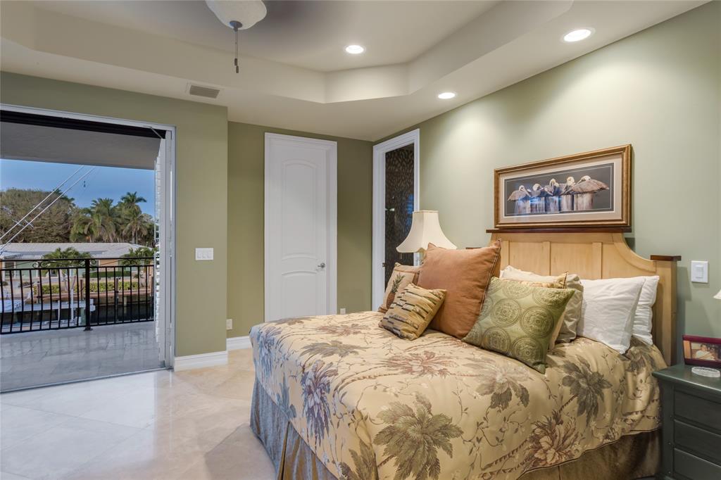 3489 Northeast 30th Avenue Lighthouse Point, FL 33064 - Photo 33 of 42 a large bed sitting in a bedroom next to a balcony