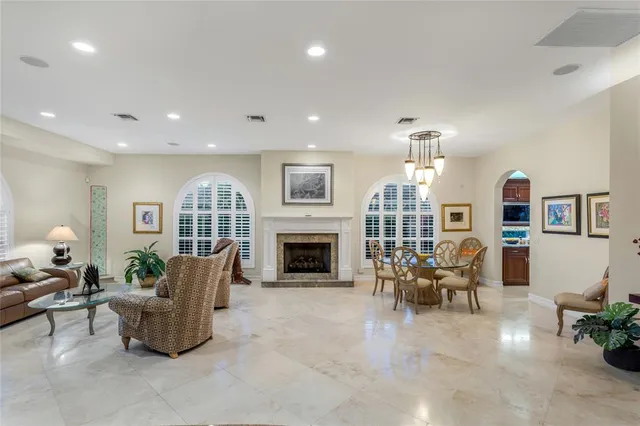 a living room with furniture a fireplace and a chandelier