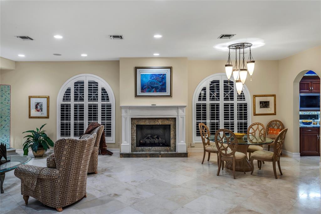 3489 Northeast 30th Avenue Lighthouse Point, FL 33064 - Photo 8 of 42 a living room with furniture a fireplace and a chandelier
