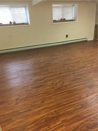 a view of a room with wooden floor and a window
