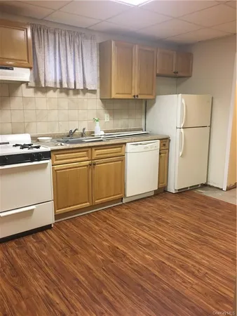 a kitchen with a sink cabinets and wooden floor