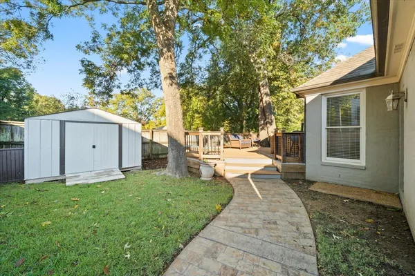 a view of a house with backyard and a tree