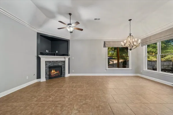 a view of an empty room with a fireplace and a window